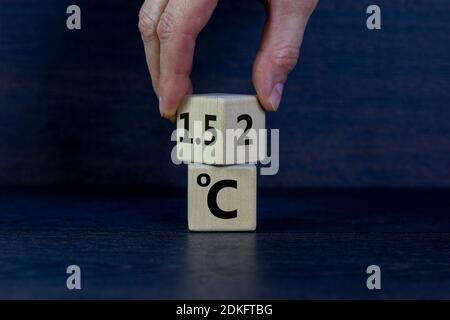Symbol für die Begrenzung der globalen Erwärmung. Männliche Hand dreht einen Würfel und ändert den Ausdruck '2 C' in '1.5 C', oder umgekehrt. Geschäftskonzept. Wunderschön da Stockfoto
