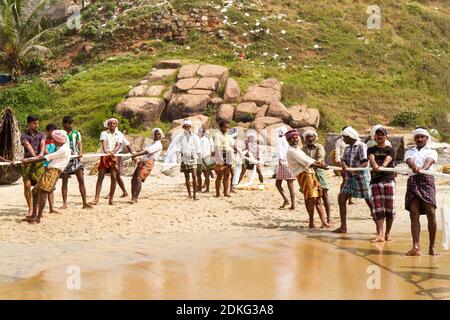 Kovalam, Kerala, INDIEN - JAN 15: Fischer ziehen ein Fischernetz aus dem Arabischen Meer am 15. JAN 2012 in Kovalam, Kerala, Indien. Stockfoto