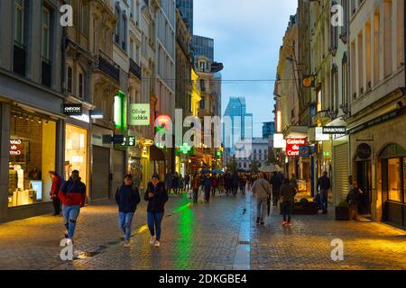 BRÜSSEL, BELGIEN - 06. OKTOBER 2019: Menschenmenge, die in der Dämmerung an der Einkaufsstraße der Altstadt von Brüssel spazieren Stockfoto
