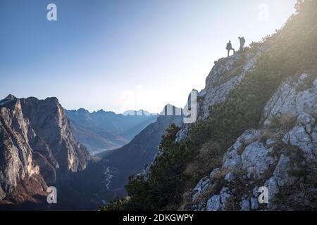 Italien, Venetien, Belluno, Taibon Agordino, Dolomiten. Zwei Wanderer erklimmen eine Wand mit Blick auf das Tal von san lucano, auf der linken Seite die Gruppe Pale di San Lucano Stockfoto