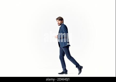 Ein Mann auf einem hellen Hintergrund geht und springt zu Die Seite in der Unternehmensfinanzierung mit vollem Wachstum Stockfoto