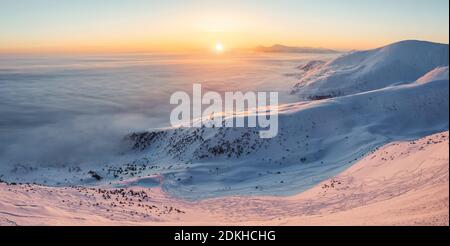 Panoramablick. Landschaft mit hohen Bergen, Morgennebel und schönem Sonnenaufgang. Orangefarbener Himmel. Winterlandschaft. Hintergrund des Hintergrundbilds. Lage, Auto stellen Stockfoto