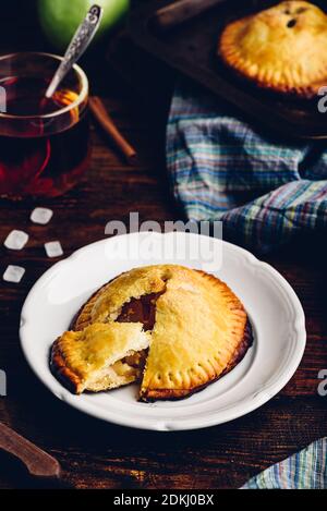 Hausgemachter Apfel Mini Pie auf weißem Teller mit Tasse Schwarzer Tee Stockfoto