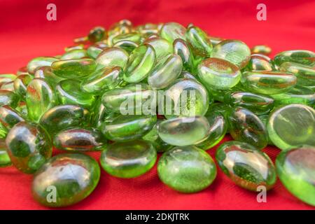 Grüne Glasperlen auf hellrotem Hintergrund Stockfoto