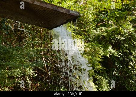 Wasser fließt aus der Rinne Stockfoto