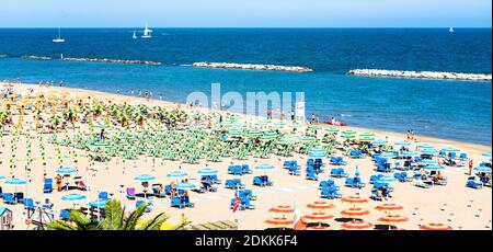 Schöne Luftaufnahme auf Menschen, die am Strand, Meer und Liegen mit Sonnenschirmen oder Sonnenschirm am Sommertag ruhen. Adriaküste, Rimini, Italien. Gabicce Stockfoto