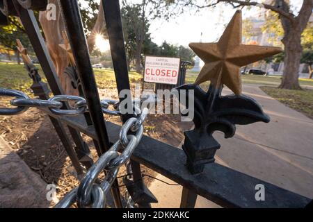 Austin, TX USA 15. Dezember 2020: Schild mit der Aufschrift 'Capitol Building and Grounds CLOSED to all Visitors' sitzt hinter den verschlossenen Toren des Texas Capitol in Austin am Abend bevor der Gouverneur von Texas, Greg Abbott, die Wiedereröffnung des Geländes für die Öffentlichkeit anordnete. Das Capitol ist seit Monaten geschlossen, nachdem Vandalismus auf dem Gelände und Gebäude während der Proteste gegen Polizeigewalt nach dem Mord an George Floyd im Mai 2020. Kredit: Bob Daemmrich/Alamy Live Nachrichten Stockfoto