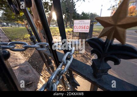 Austin, TX USA 15. Dezember 2020: Schild mit der Aufschrift 'Capitol Building and Grounds CLOSED to all Visitors' sitzt hinter den verschlossenen Toren des Texas Capitol in Austin am Abend bevor der Gouverneur von Texas, Greg Abbott, die Wiedereröffnung des Geländes für die Öffentlichkeit anordnete. Das Capitol ist seit Monaten geschlossen, nachdem Vandalismus auf dem Gelände und Gebäude während der Proteste gegen Polizeigewalt nach dem Mord an George Floyd im Mai 2020. Kredit: Bob Daemmrich/Alamy Live Nachrichten Stockfoto
