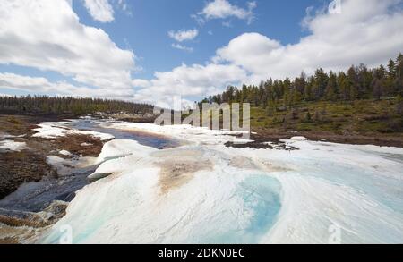 Frühlingslandschaft im Tal eines Baches mit Sahnehäubchen bedeckt in Süd-Jakutien, Russland Stockfoto