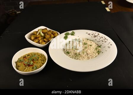 Jeera Reis serviert mit Kartoffelchaat und Dal braten Stockfoto