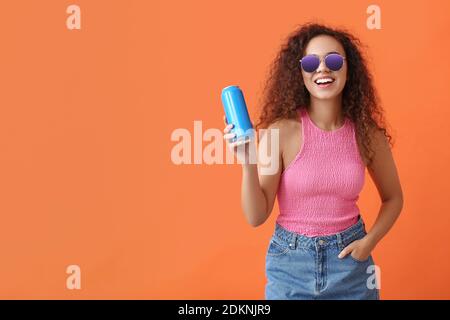 Schöne afroamerikanische Frau mit Soda auf farbigem Hintergrund Stockfoto