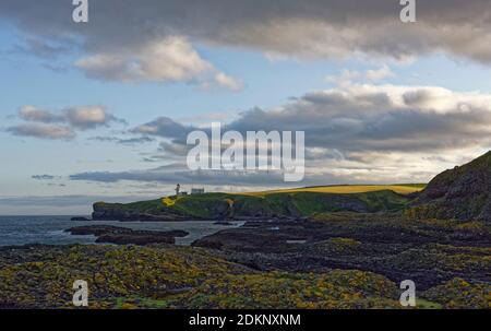 Tod Head Leuchtturm und zugehörige Gebäude beleuchtet durch die Letzte der Abendsonne als die Schatten der Nacht kriechen durch die Landschaft bei Catterl Stockfoto