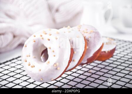 Donut auf dem Backblech glasiert mit weißer Schokoladencreme oder Glasur. Stockfoto