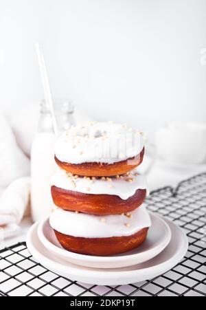 Stapel von Donut auf der Platte glasiert weiße Schokolade Sahne oder Glasur. Stockfoto