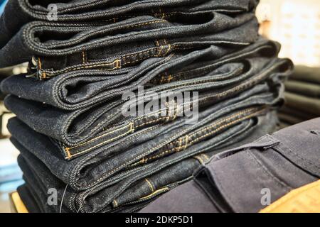 Stapel von Denim-Hosen hängen auf dem Regal des Einzelhandels Stockfoto