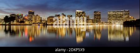 Oakland, Kalifornien - 14. Dezember 2020: Dämmerung Reflexionen von Downtown Oakland über Lake Merritt Stockfoto