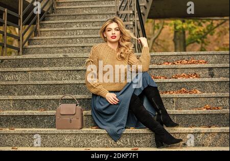 Netter Tag. Mädchen in Wellrock und Pullover. Plissierter Trend. Herbstfrau lockiges Haar im Freien. Legere Style-Studentin. Herbstsaison. Mädchen lange blonde Haartreppen. Weibliche Schönheit. Modemodell. Stockfoto