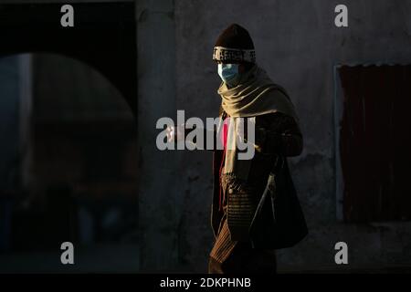 Kathmandu, Nepal. Dezember 2020. Ein eifriger Anhänger, der eine Gesichtsmaske trägt, geht für ein Ritual in Richtung zu Herrn Shiva am Pashupatinath Tempel.der Pashupatinath Tempel hat zu den eifrigen Anhängern durch Annahme der Gesundheitssicherheitsprotokolle wieder geöffnet. Wegen des Coronavirus wurden seit dem 20. März 2020 Tempel für Anhänger geschlossen. Pashupatinath ist einer der vier wichtigsten und berühmtesten hinduistischen religiösen Tempel in Asien für Anhänger von Shiva. Kredit: SOPA Images Limited/Alamy Live Nachrichten Stockfoto