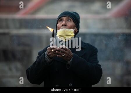 Kathmandu, Nepal. Dezember 2020. Ein nepalesischer Hindu-Mann, der eine Gesichtsmaske trägt, bietet Lord Shiva rituelle Gebete im Pashupatinath Tempel an.der Pashupatinath Tempel hat für die eifrigen Anhänger durch die Annahme von Gesundheitsprotokollen wieder geöffnet. Wegen des Coronavirus wurden seit dem 20. März 2020 Tempel für Anhänger geschlossen. Pashupatinath ist einer der vier wichtigsten und berühmtesten hinduistischen religiösen Tempel in Asien für Anhänger von Shiva. Kredit: SOPA Images Limited/Alamy Live Nachrichten Stockfoto