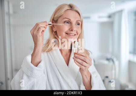 Ziemlich elegante Frau mit natürlichen kosmetischen Produkt für hydratisiert und Gesichts gesunde Derma Stockfoto