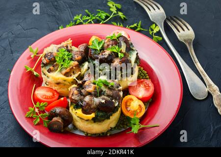 Polenta oder Maisbrei mit Pilzen und Spinat.Italienische Küche. Stockfoto