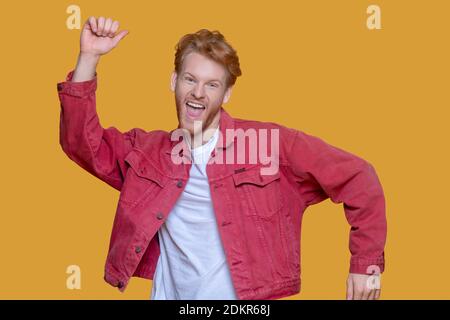 Rothaarige bärtige junge Mann in roter Jacke Gefühl aufgeregt Stockfoto