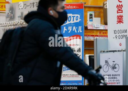 Tokio, Japan. Dezember 2020. Ein Schild der Go to Travel Kampagne ist auf dem Display vor einem elektronischen Geschäft in der Nähe von Ginza Bereich. Die japanische Regierung hat beschlossen, die Kampagne Go to Travel von Dezember 28 bis Januar 11 landesweit auszusetzen, um die Menschen zu schützen und die Ausbreitung des Virus zu verhindern. In Tokio wird aufgrund der hohen Zahl von Coronavirus-Fällen in der Hauptstadt ab Freitag (18. Dezember) der Inlandsreisezuschuss abgesetzt. Quelle: Rodrigo Reyes Marin/ZUMA Wire/Alamy Live News Stockfoto