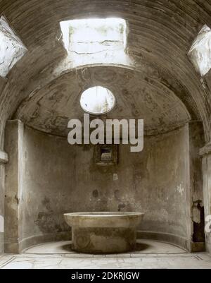 Italien, Pompeji. Die Thermalbäder des Forums. Öffentliche Bäder, unmittelbar nach der Gründung der Kolonie (nach 80 v. Chr.) erbaut. Sie wurden in Männer- und Frauenabteilung unterteilt. Zimmer des 'Calidarium' mit seiner Heißwasserfledermaus. Waschbecken, das mit kaltem Wasser gefüllt war, damit sich die Badegäste abkühlen konnten. Stockfoto