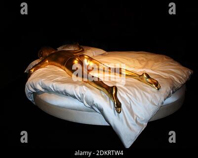 Ausstellung aus der Ausstellung Designing 007: 50 Jahre Bond Style im Londoner Barbican EINE Replik von Goldfingers Shirley Eaton liegt tot auf einem zerbröckelten Bett Stockfoto