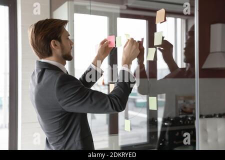 Junger kaukasischer männlicher Angestellter engagiert in kreativem Denken Stockfoto