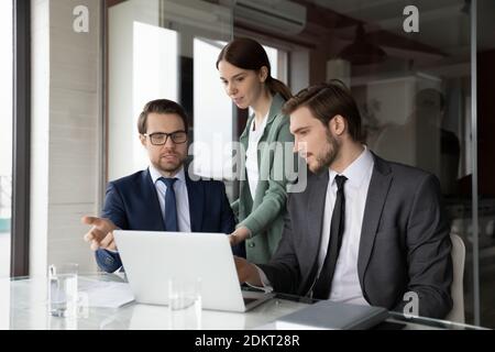 Verschiedene Mitarbeiter arbeiten bei Büromeeting am Laptop Stockfoto