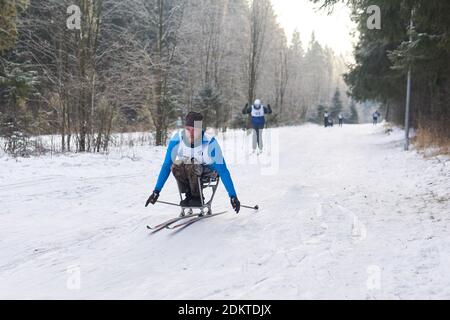 Perm, Russland - 12. Dezember 2020: Sportler mit einer Disabilitiy nimmt an Langlauf-Ski-Wettbewerb auf einer Strecke im Wald Stockfoto