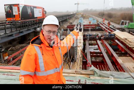 16. Dezember 2020, Mecklenburg-Vorpommern, Tribsees: Vor der Baustelle für die neue Brücke steht der Mecklenburg-Vorpommern-Minister für Infrastruktur, Christian Pegel (SPD), bei einer Presseveranstaltung auf der abgeklerten OSTSEESTRASSE 20. Insgesamt werden 308 Bohrpfähle für die fast 800 Meter lange Nordhälfte der Brücke in den Boden getrieben, 254 sind bereits im Boden. Die Arbeiten begannen im April 2020 und liegen im Zeitplan. Die erste Hälfte der Brücke soll im Herbst 2021 fertiggestellt werden, die Fertigstellung der A20 ist für 2023 geplant. Die Autobahn, bui Stockfoto