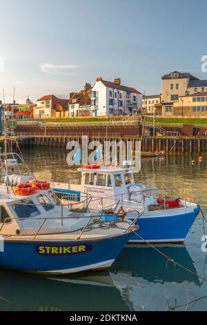 Blick auf Hafenboote und Hafengeschäfte in Bridlington Harbour bei Sonnenuntergang, Bridlington, East Yorkshire, England, Großbritannien, Europa Stockfoto