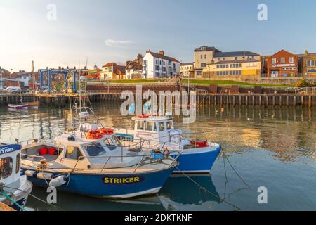 Blick auf Hafenboote und Hafengeschäfte in Bridlington Harbour bei Sonnenuntergang, Bridlington, East Yorkshire, England, Großbritannien, Europa Stockfoto