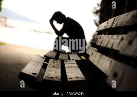 Deprimiert aussehende Silhouette eines Mannes, der im Tunnel sitzt. Dramatisches Konzept. Einsamkeit Konzept. Stockfoto