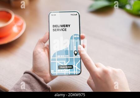 Frau mit Smartphone mit geöffneten Lieferservice Tracking-App, Überprüfung des Bestellstatus Stockfoto