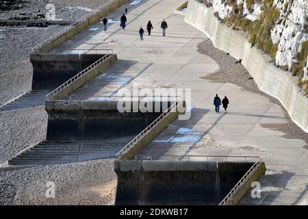 An einem sonnigen Tag in der Nähe von Rottingdean, East Sussex, England, Vereinigtes Königreich, spazieren Sie mit Menschen entlang eines Strandpfads Stockfoto