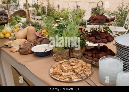 Eine Auswahl an Speisen in Schüsseln auf einem Buffettisch Während einer Tagesveranstaltung Stockfoto