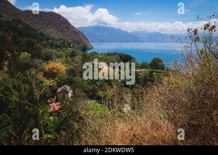 Blick von oben vom Berg an der grünen Küste entlang des Atitlan Sees bei Santa Cruz la Laguna, Guatemala Stockfoto