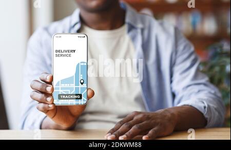 Black Man Demonstriert Smartphone Mit Geöffneten Delivery Service Tracking App Auf Dem Bildschirm Stockfoto