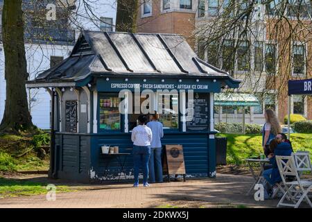 Brodies Coffee Co Hütte im Park (Leute stehen in der Schlange, um Essen und Getränke im Freien zu kaufen, Gäste sitzen an Tischen) - Gorsedd Gardens, Cardiff, Wales, UK Stockfoto