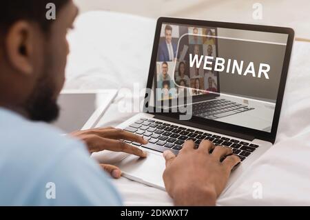 Afroamerikanischer Mann mit Webinar auf modernem Laptop Stockfoto