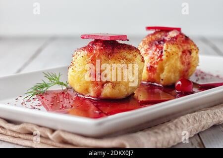 Frisch gekochte schwedische Kartoffelknödel mit Preiselbeersauce auf hellem Hintergrund. Stockfoto