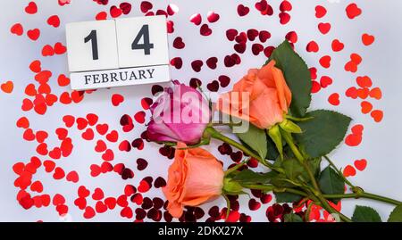 Blumenstrauß mit Herzen und einem Holzkalender mit dem Datum Februar 14. Valentinstag. Stockfoto