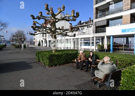 Friedrichshafen, Deutschland. März 2020. Drei Rentner sitzen zusammen an der Uferpromenade und trinken Kaffee. Nur wenige Menschen laufen mittags am Ufer des Bodensees entlang. Im Kampf gegen die Corona-Pandemie hat in Deutschland am 16.12.2020 um 0.00 Uhr eine harte Sperre begonnen. Einzelhändler müssen landesweit schließen, Ausnahmen gelten nur für Geschäfte, die den täglichen Bedarf decken. Quelle: Felix Kästle/dpa/Alamy Live News Stockfoto