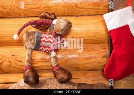 Neujahr Stillleben von vier roten Neujahrssocke für Geschenke, Spielzeug in Form eines Plüsch weihnachtshirsch auf dem Hintergrund einer Holzwand in einem Land h Stockfoto