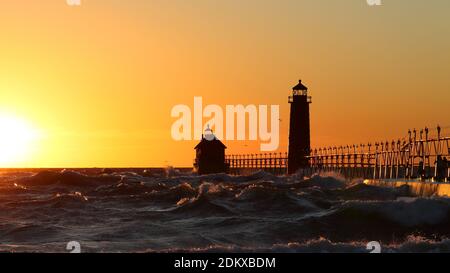 Grand Haven South Pier Leuchtturm bei Sonnenuntergang am Lake Michigan, an einem windigen Tag Stockfoto