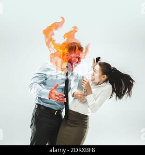 Chef mit Kopf in Brand schreiend wütend auf den Manager. Copyspace, um Ihren Text einzufügen. Modernes Design. Zeitgenössische Kunst. Kreative konzeptuelle und bunte Collage. Lifestyle-Konzept für Büromitarbeiter. Stockfoto