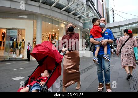 Kuala Lumpur, Malaysia. Dezember 2020. Menschen mit Gesichtsmasken gehen auf einer Straße in Kuala Lumpur, Malaysia, 16. Dezember 2020. Malaysia meldete 1,295 neue COVID-19-Infektionen, teilte das Gesundheitsministerium am Mittwoch mit und brachte die nationale Gesamtzahl auf 87,913. Quelle: Chong Voon Chung/Xinhua/Alamy Live News Stockfoto